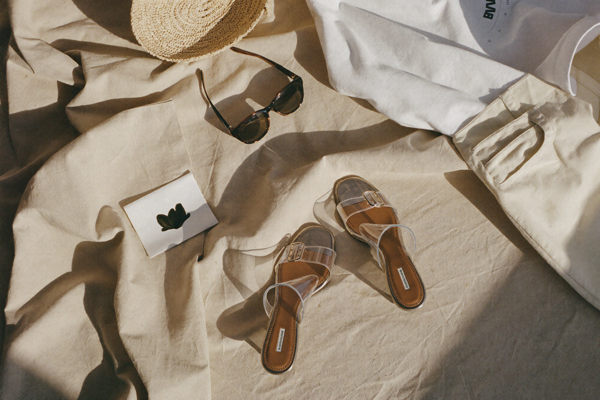 Fashion creator flat lay featuring clear jelly sandals styled with summer wardrobe details
